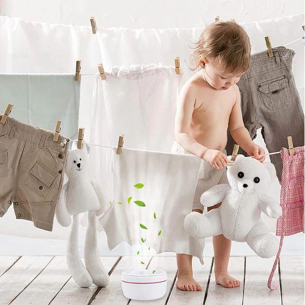 Child playing with stuffed animals on a clothesline with hanging clothes.