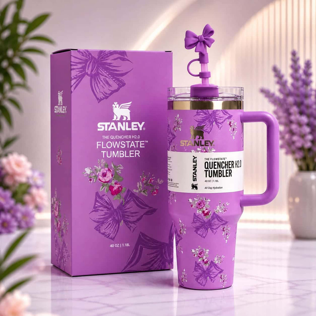 Purple Stanley tumbler with floral design and packaging on a light background