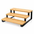 Three-step wooden platform with black metal frame on a white background
