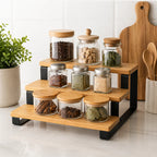 Wooden spice rack with glass jars containing various spices on a kitchen counter.